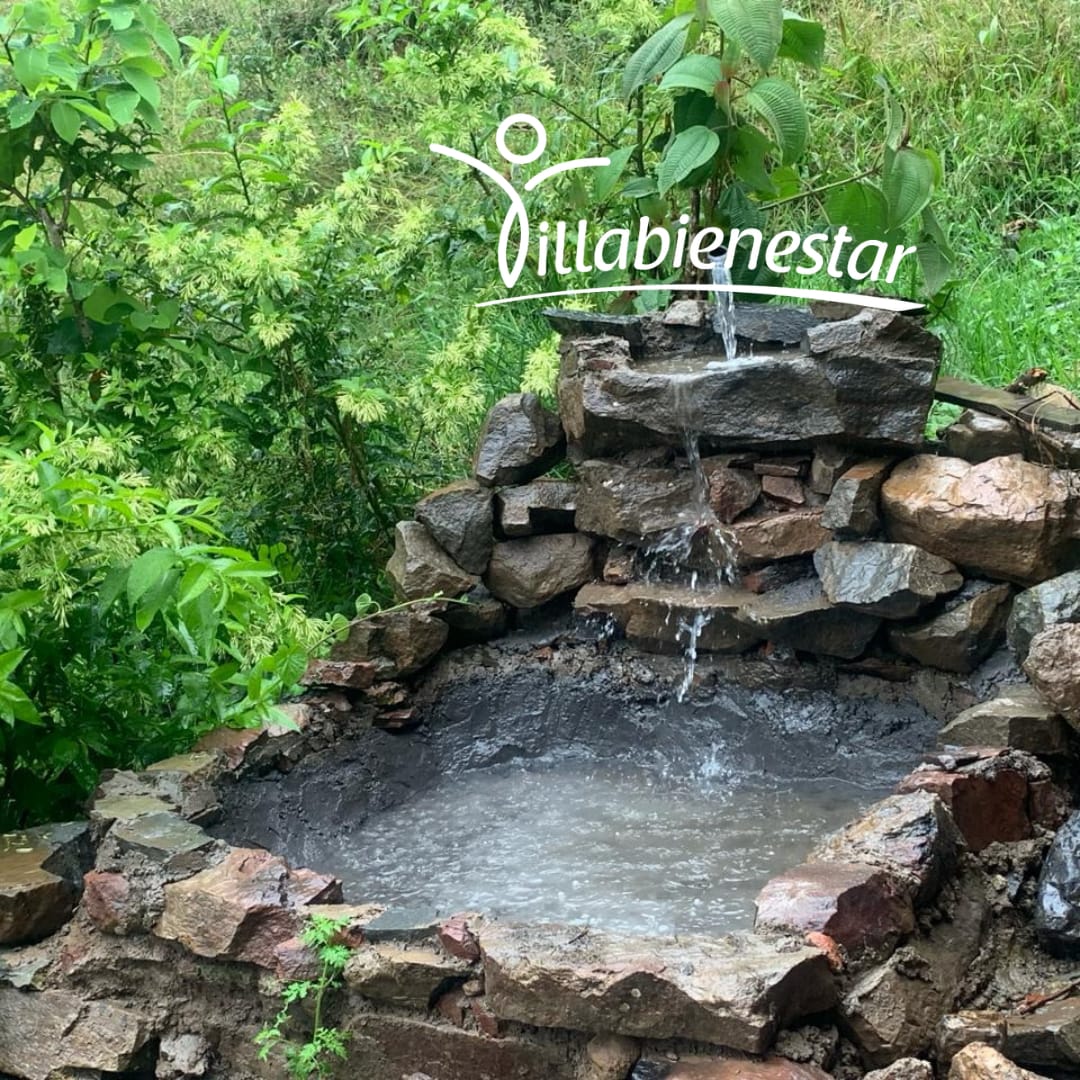 Fuente de piedra con agua en el jardín de Villa Bienestar